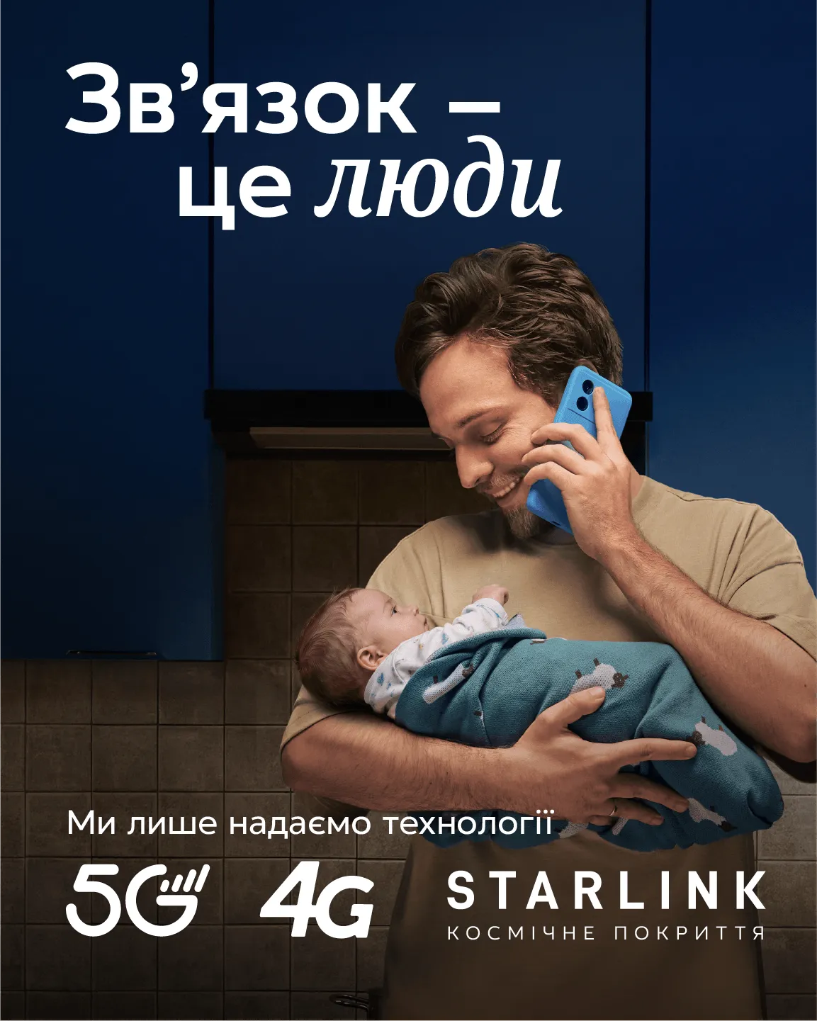 Зв'язок це люди. Чоловік тримає немовля і розмовляє по смартфону