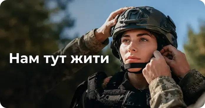 Військова надягає шолом у лісі. Напис «Нам тут жити»